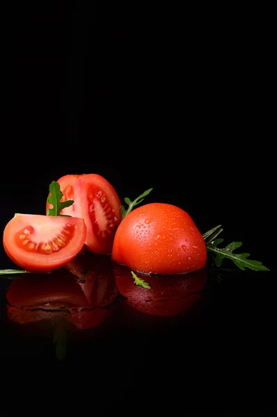 Pomodoro isolato su fondo nero e lucido con riflesso realistico e gocce d'acqua — Foto Stock