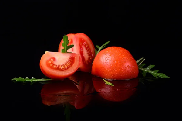 Pomodoro isolato su fondo nero e lucido con riflesso realistico e gocce d'acqua — Foto Stock