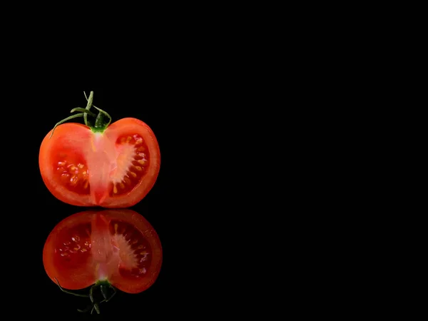 Tomate isoliert auf dem schwarzen und glänzenden Hintergrund mit realistischer Reflexion und Wassertropfen — Stockfoto