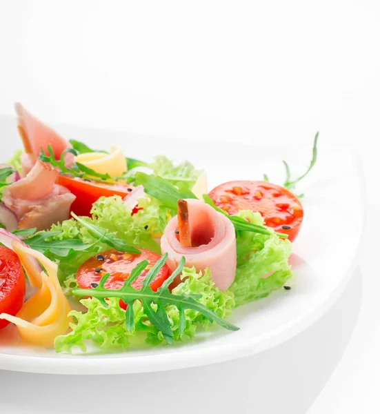 Fresh salad with tomatoes, arugula, cheese and ham on the white plate and white background — Stock Photo, Image