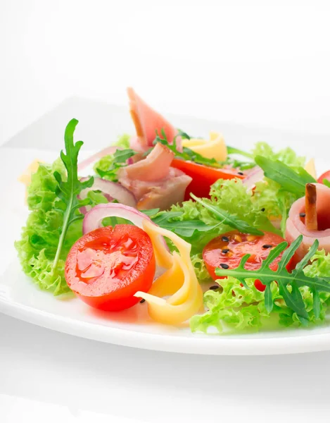 Fresh salad with tomatoes, arugula, cheese and ham on the white plate and white background — Stock Photo, Image