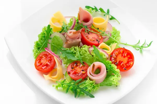 Fresh salad with tomatoes, arugula, cheese and ham on the white plate and white background — Stock Photo, Image