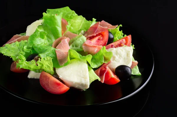 Salad segar lezat pada latar belakang hitam mengkilap — Stok Foto