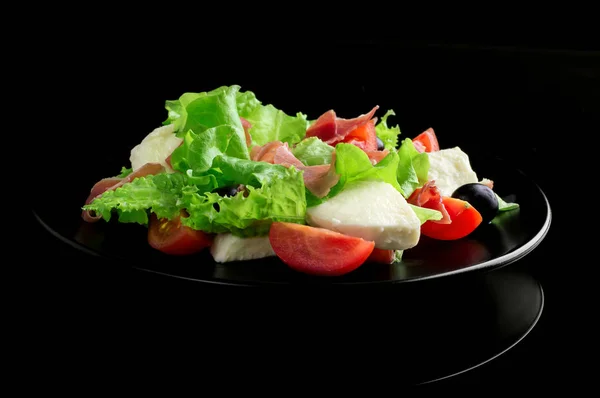 Fresh tasty salad on a glossy black background — Stock Photo, Image