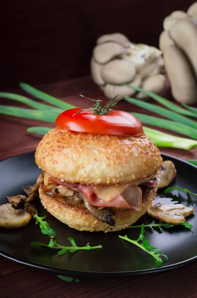 Burger, smażone pieczarki, szynkę, cebulę i ser na tle rustykalnym — Zdjęcie stockowe