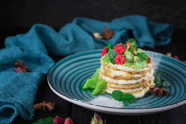 Delicioso pastel con decoración de frutas y menta sobre fondo negro — Imagen de stock Delicioso pastel con decoración de frutas y menta sobre fondo negro Imagen De Stock