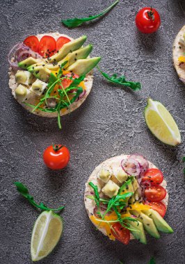 Bruschetta domates, avokado, otlar ve roka ile. Rustik arka plan. Üstten Görünüm