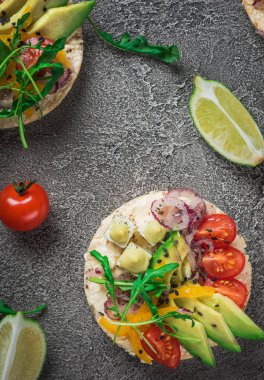 Bruschetta domates, avokado, otlar ve roka ile. Rustik arka plan. Üstten Görünüm