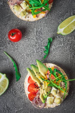 Bruschetta domates, avokado, otlar ve roka ile. Rustik arka plan. Üstten Görünüm