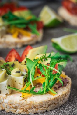 Bruschetta domates, avokado, otlar ve roka ile. Rustik arka plan. Üstten Görünüm