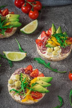 Bruschetta domates, avokado, otlar ve roka ile. Rustik arka plan. Üstten Görünüm