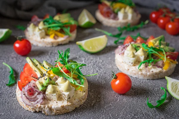 Bruschetta con pomodoro, avocado, erbe aromatiche e rucola. Sfondo rustico. Vista dall'alto — Foto Stock