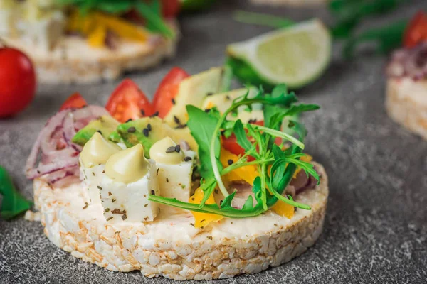 Bruschetta con pomodoro, avocado, erbe aromatiche e rucola. Sfondo rustico. Vista dall'alto — Foto Stock