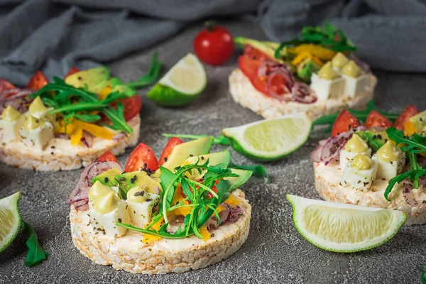 Bruschetta with tomato, avocado, herbs and arugula. Rustic background. Top view — Stock Photo, Image