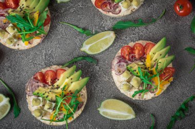 Bruschetta domates, avokado, otlar ve roka ile. Rustik arka plan. Üstten Görünüm