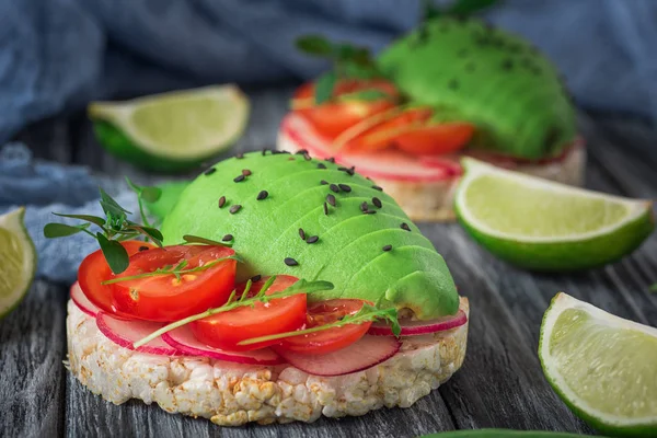 Bruschetta met tomaat, avocado, kruiden en rucola. Rustieke achtergrond. Bovenaanzicht — Stockfoto