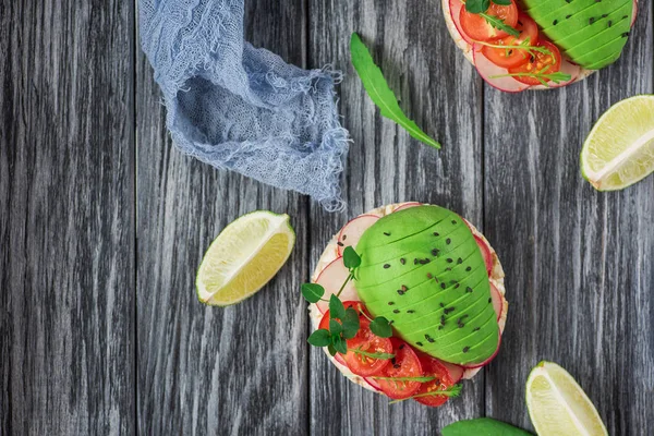 Brosse à la tomate, avocat, herbes et roquette. Fond rustique. Vue du dessus — Photo