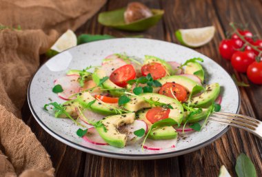Avokado, roka, turp, limon ve zeytinyağı sebze salatası. Diyet sağlıklı gıda. Ahşap rustik arka plan. Üstten Görünüm
