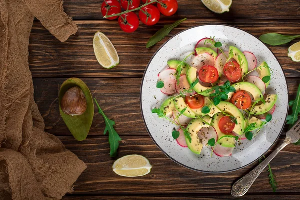 アボカド、ルッコラ、ラディッシュ、ライム、オリーブ オイルと野菜のサラダ。ダイエット健康食品です。木製の素朴な背景。トップ ビュー — ストック写真