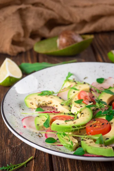 Avokado, roka, turp, limon ve zeytinyağı sebze salatası. Diyet sağlıklı gıda. Ahşap rustik arka plan. Üstten Görünüm