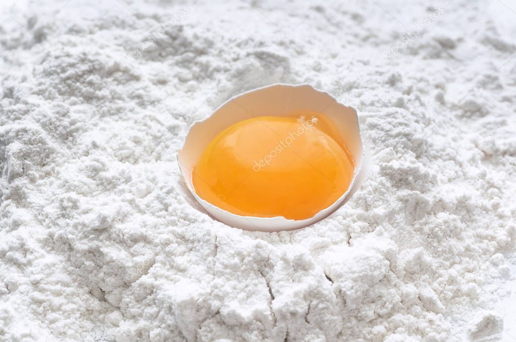 Fresh egg in wheat flour isolated on white background as package design element. Top view