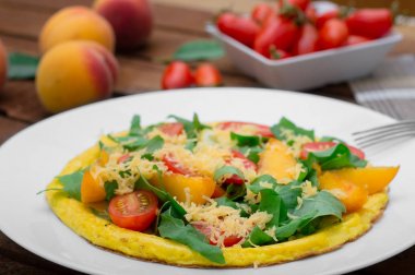 Frittata şeftali, sebze ve peynir rustik ahşap arka plan üzerinde beyaz bir plaka ile. Üstten Görünüm