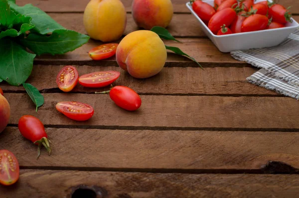Зрізати персики і помідори на дерев'яному тлі. Вид зверху — стокове фото