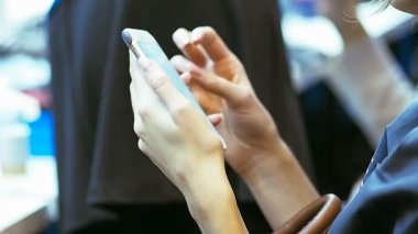 Genç kadın modeli saç stilisti için beklerken bir cep telefonu kullanmak