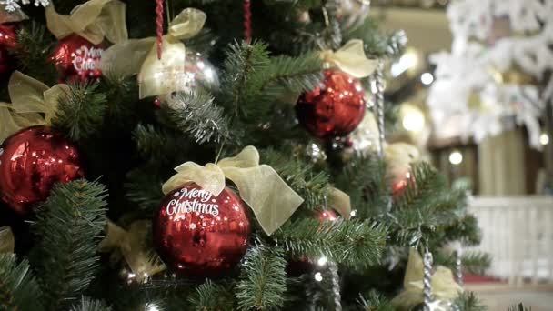 Resumen Blurred shopping mall background with Christmas decorations. Bolas de oro y rojas con viento . — Vídeos de Stock