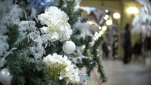 白いボールと花です。正月とクリスマス ツリーの飾りと抽象的なぼやけたショッピング モール背景. — ストック動画