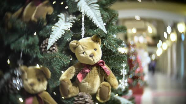 Plush bear balls and fir cone. New Years and abstract blurred shopping mall background with Christmas tree decorations. — Stock Video