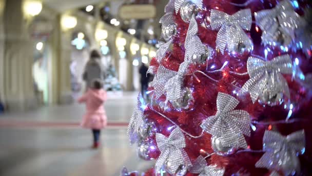 Smrk červený v stříbrná mašle. Nový rok a pozadí abstraktní rozmazané nákupní centrum s vánoční ozdoby. — Stock video