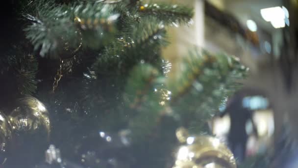Deslize para dentro de bolas de ouro fosco e espelho. Ano Novo e abstrato desfocado shopping center fundo com decorações de árvore de Natal . — Vídeo de Stock