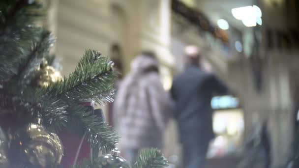 Gleiten aus goldenen Matte- und Spiegelkugeln. Silvester und abstrakte verschwommene Shopping Mall Hintergrund mit Christbaumschmuck. — Stockvideo