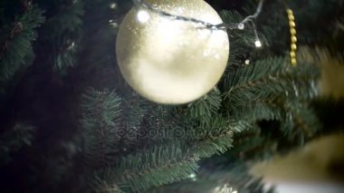 Büyük altın mat top ışıkları bir bakış kaymak. Yeni yıl ve yılbaşı ağacı süsleri ile soyut bulanık alışveriş arka plan.