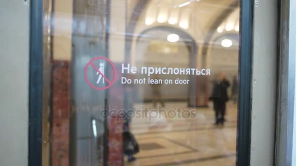 Mayakovskaya, Moskova metro istasyonuna davetçiler. Metro etiketli cam kapı görünümünden "dikkat ediniz kapıda" — Stok video