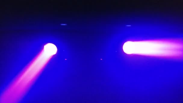 Two spotlights of purple color on the ceiling of the techno club blink and rotate — Stock Video
