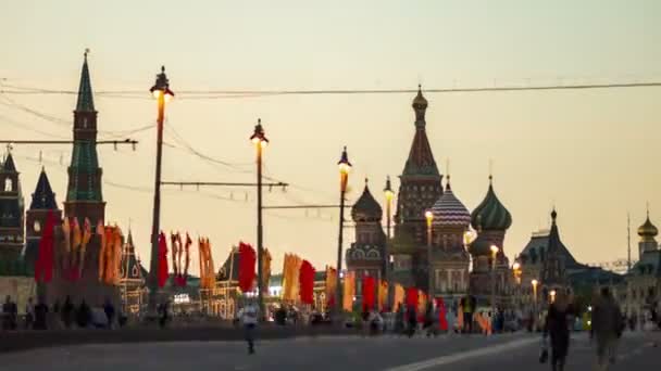 Uitzicht op de St. Basils Cathedral vanaf de Bolsjoj Moskvoretsky brug avond met mensen lopen op 9 mei — Stockvideo