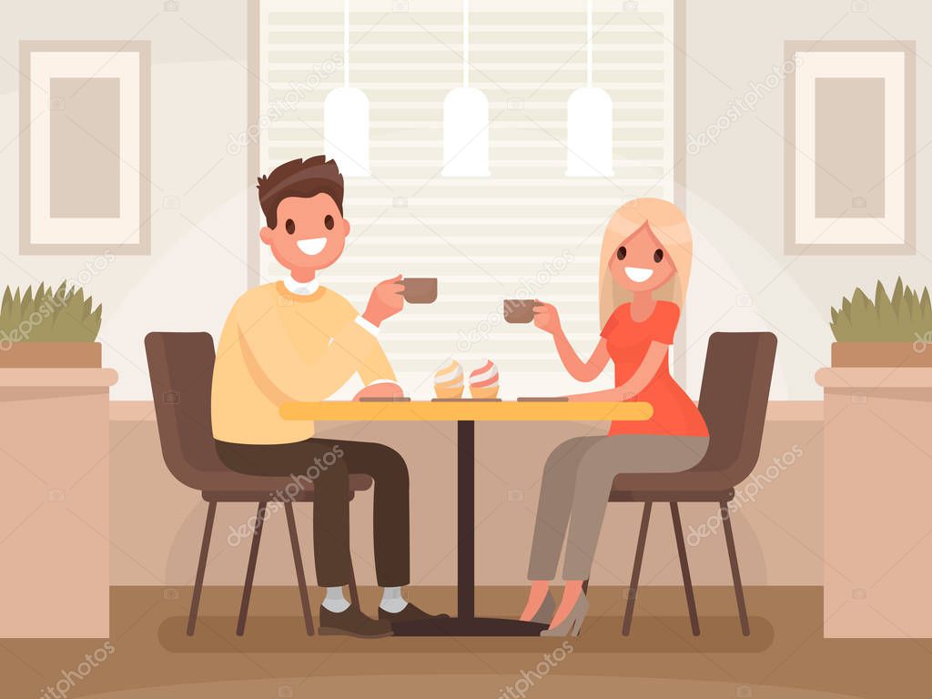 Loving couple is drinking coffee in a cafe. A man and a woman ar