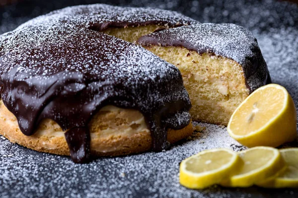 自家製チョコレート ケーキ カット作品黒い背景にレモンと粉砂糖を振りかけた — ストック写真