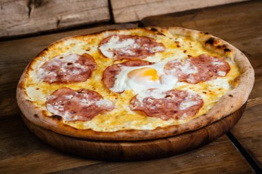 Jambon ve yumurta ahşap arka plan üzerinde pizza