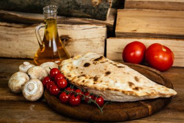  alzone pizza malzemelerle ahşap masa üzerinde