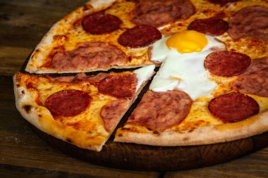 Jambon, sosis ve yumurta ahşap arka plan üzerinde pizza