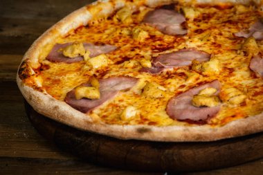 Jambon ve ahşap arka plan üzerinde tavuk pizza