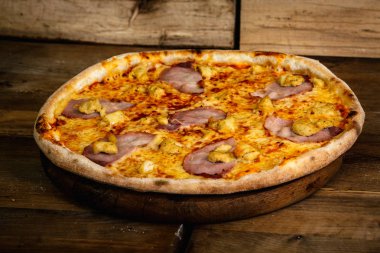 Jambon ve ahşap arka plan üzerinde tavuk pizza