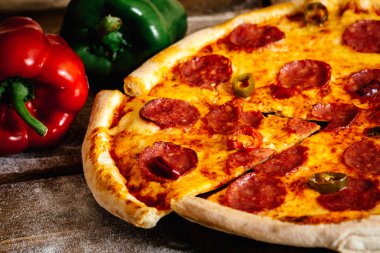 Sosis ve biber malzemelerle ahşap masa üzerinde tüm pizza