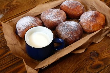 Çörek fincan süt tahta arka plan ile. 