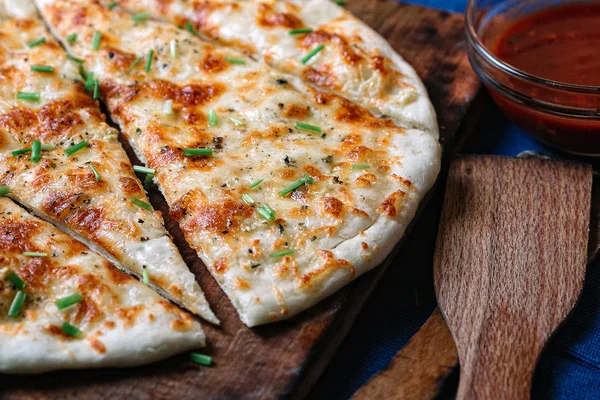 Ev yapımı peynir pizza sos ahşap kesme tahtası ile
