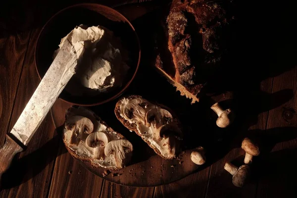 Хлеб и тосты со сливочным сыром и грибами на деревянном фоне — стоковое фото