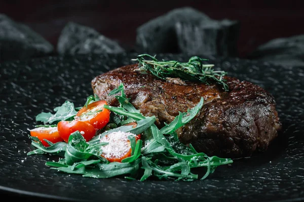 Izgara dana biftek salata koyu arka plan üzerinde